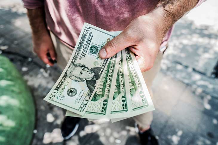 A man holding cash in his hand.