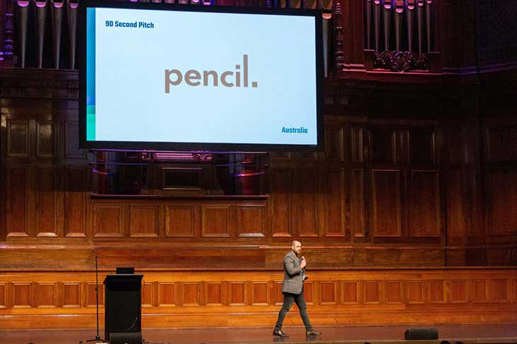 Tim Demetriou pitching his business Pencil in a large theatre.